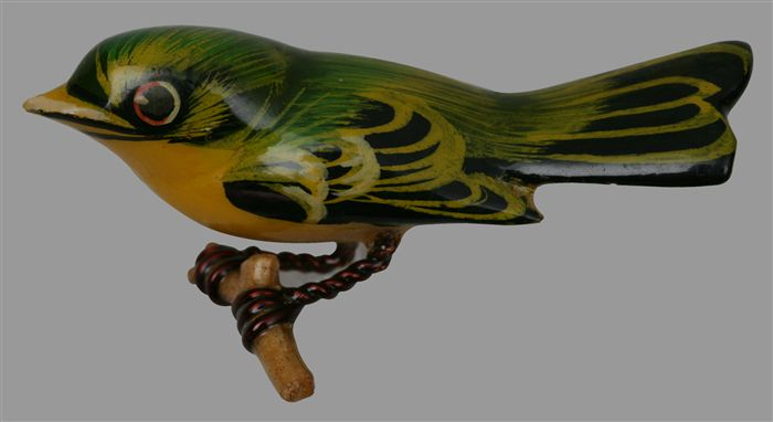 Making jewellery in a time of war:
Carved wooden bird perched on a twig. Green and yellow feathers. Made in the Poston Relocation Camp, Arizona. Manzanar National Historic Site