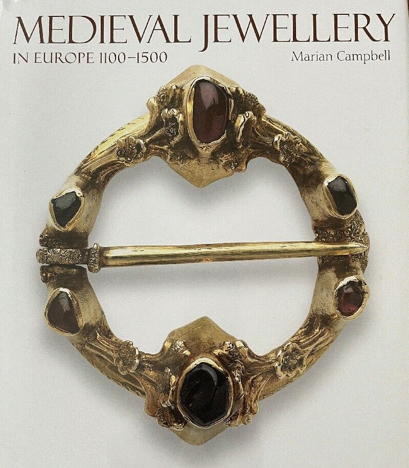 Cover image for 'Medieval Jewellery' showing a gold ring brooch set with cabochon red stones. The ring brooch has a pin across the centre.