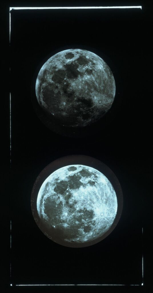 Black and white photograph of the moon - two images of the moon, are showne, one above the other. The lower image is a brighter white.