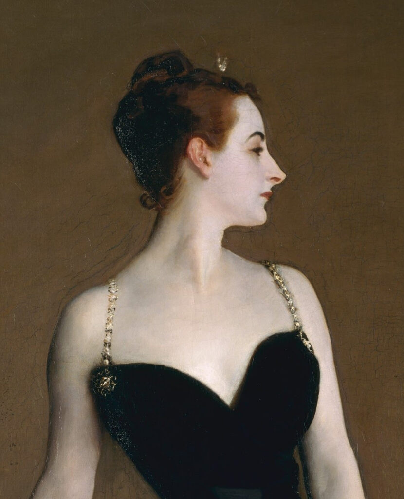 Head and shoulders of Madame X, wearing a low cut black gown with jewelled shoulder straps. Her head is turned to the left. She has dark brown hair, worn up and a diamond crescent moon hairpin is fixed above her forehead. 