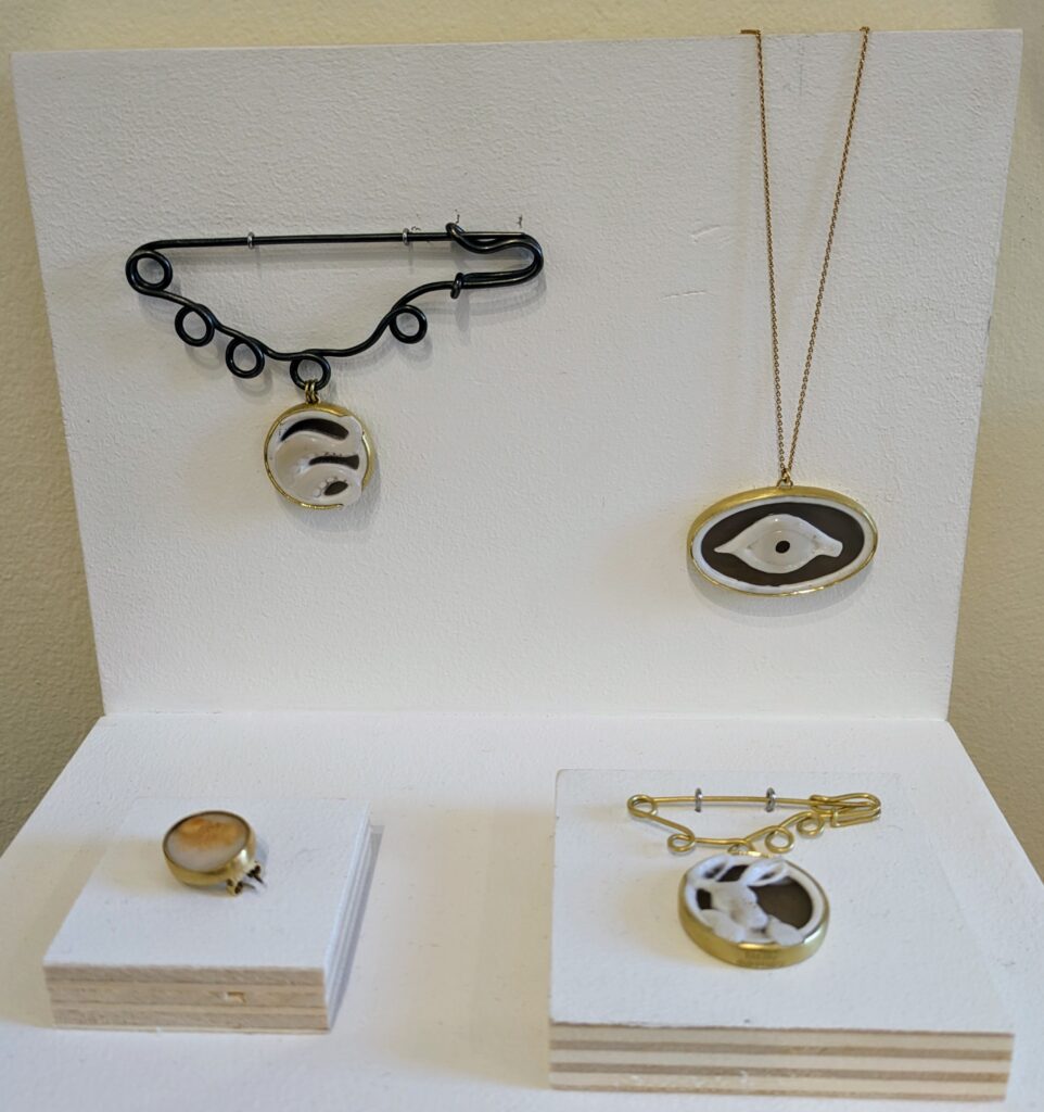 Pendants and brooches of banded agate and silver by Sian Evan, Collect 2024. 