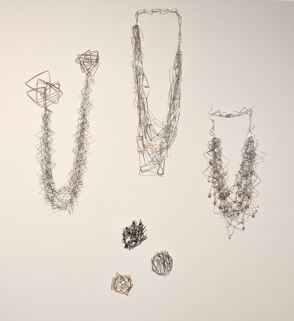 Group of silver and stainless steel necklaces and brooches by Heather McDermott for Craft Scotland. Collect 2024. 