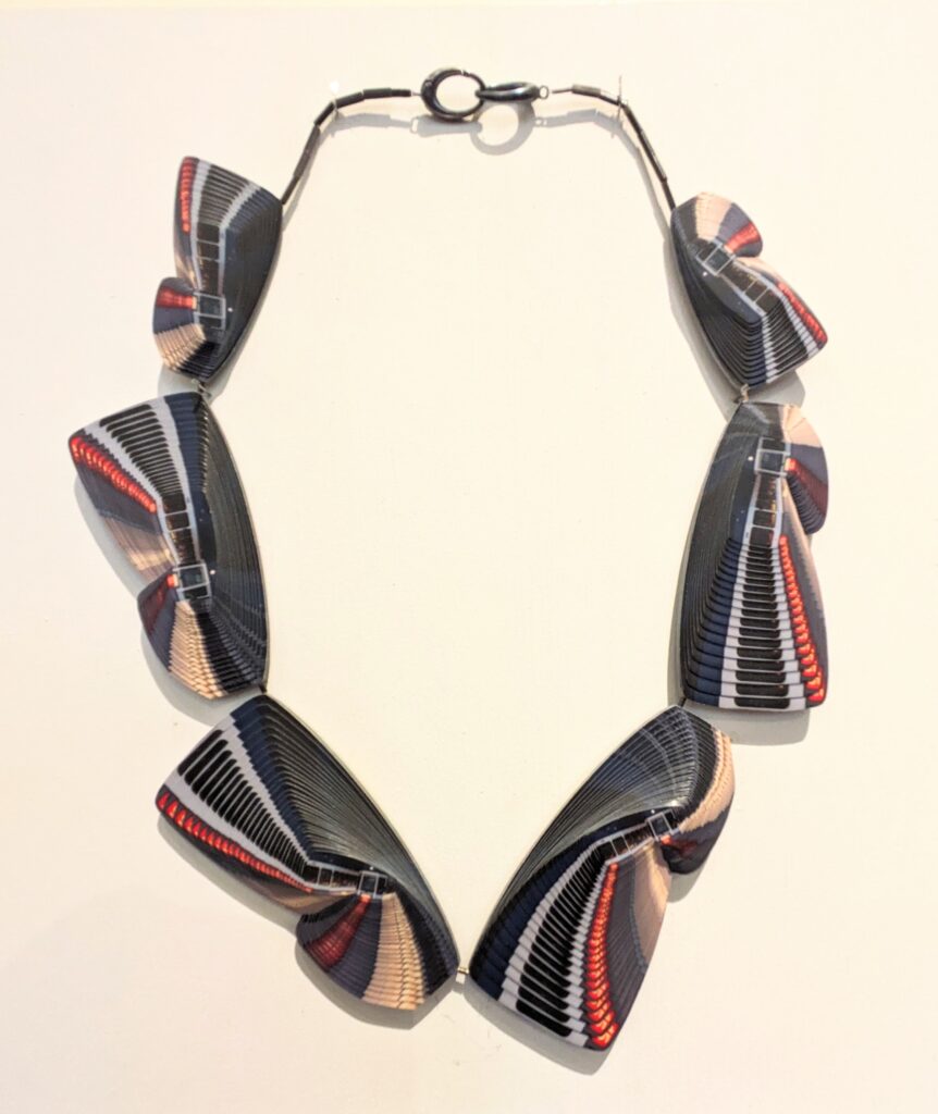 Zurich necklace by Sooyeon Kim, made up of wing shaped parts created by cutting up and overlapping photographs. 