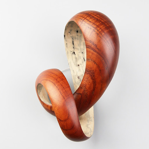 Scrolling wood and lacquer brooch by Joo Hyung Park, Collect 2024. 