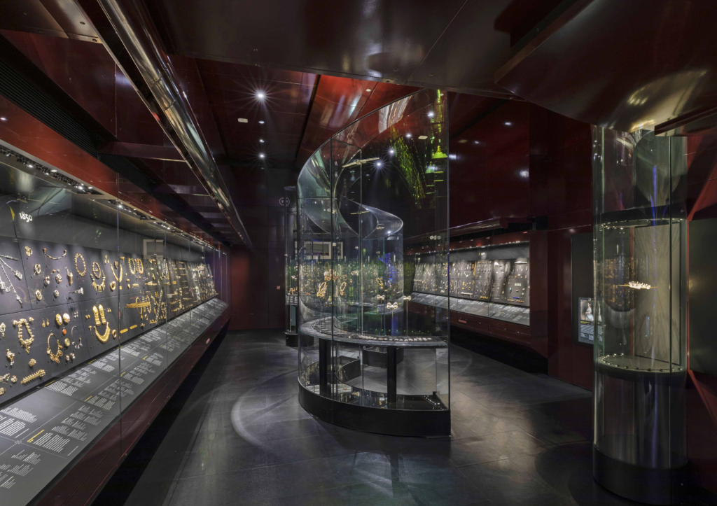 View down the V&A jewellery gallery  showing the central curved cases and the wall cases. 