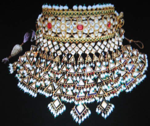 Bib style Indian necklace with a high collar. Made up of concentric rows of pearls, gems and triangles of blue stone edged in gold. 
