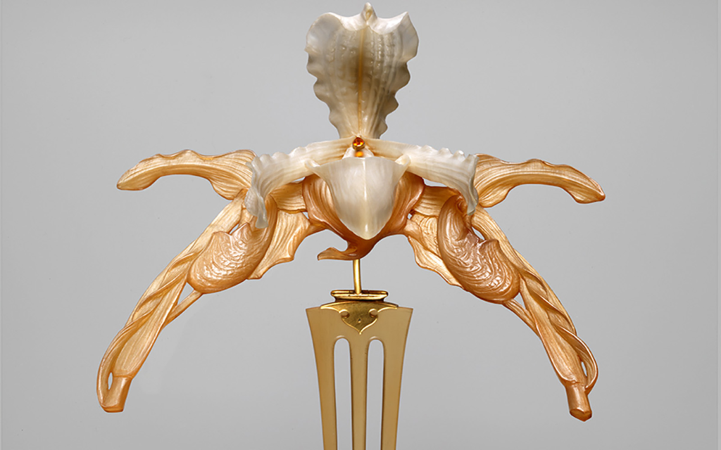 Carved horn and ivory orchid flower with three pronged gold comb to fix the haircomb into the hair. Small gold citrine in the centre of the flower. 