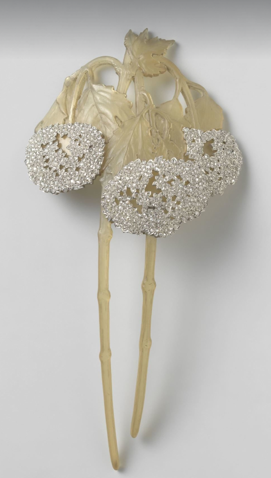 Horn and diamond hair comb, René Lalique, 1902-3. Rijksmuseum, Amsterdam

Yellow horn with three pendant veined leaves terminating in white diamond composite flower heads. Two stems carved of horn with small protrusions to represent the joins in the stem. 